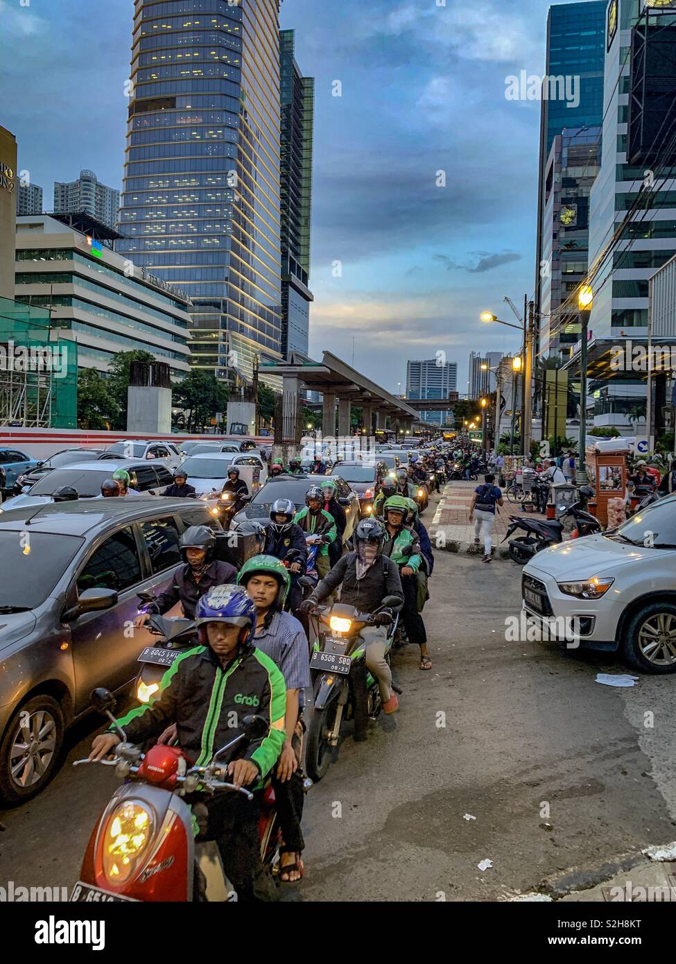 Essayant de battre le rush de Jakarta. Après le travail, l'heure de pointe, à travers le trafic de filtrage motos - Image de stock capturée avec un smartphone