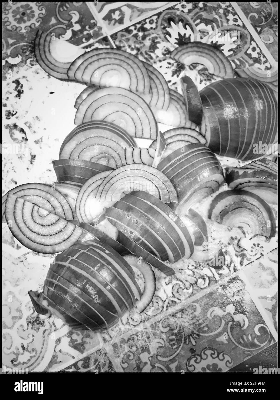 Oignons rouges tranchés sur planche à hacher.photo en noir et blanc. Banque D'Images