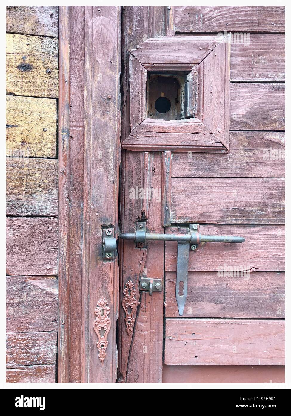 Vieille porte lambrissés avec boulon de fer et trou d'espion Banque D'Images