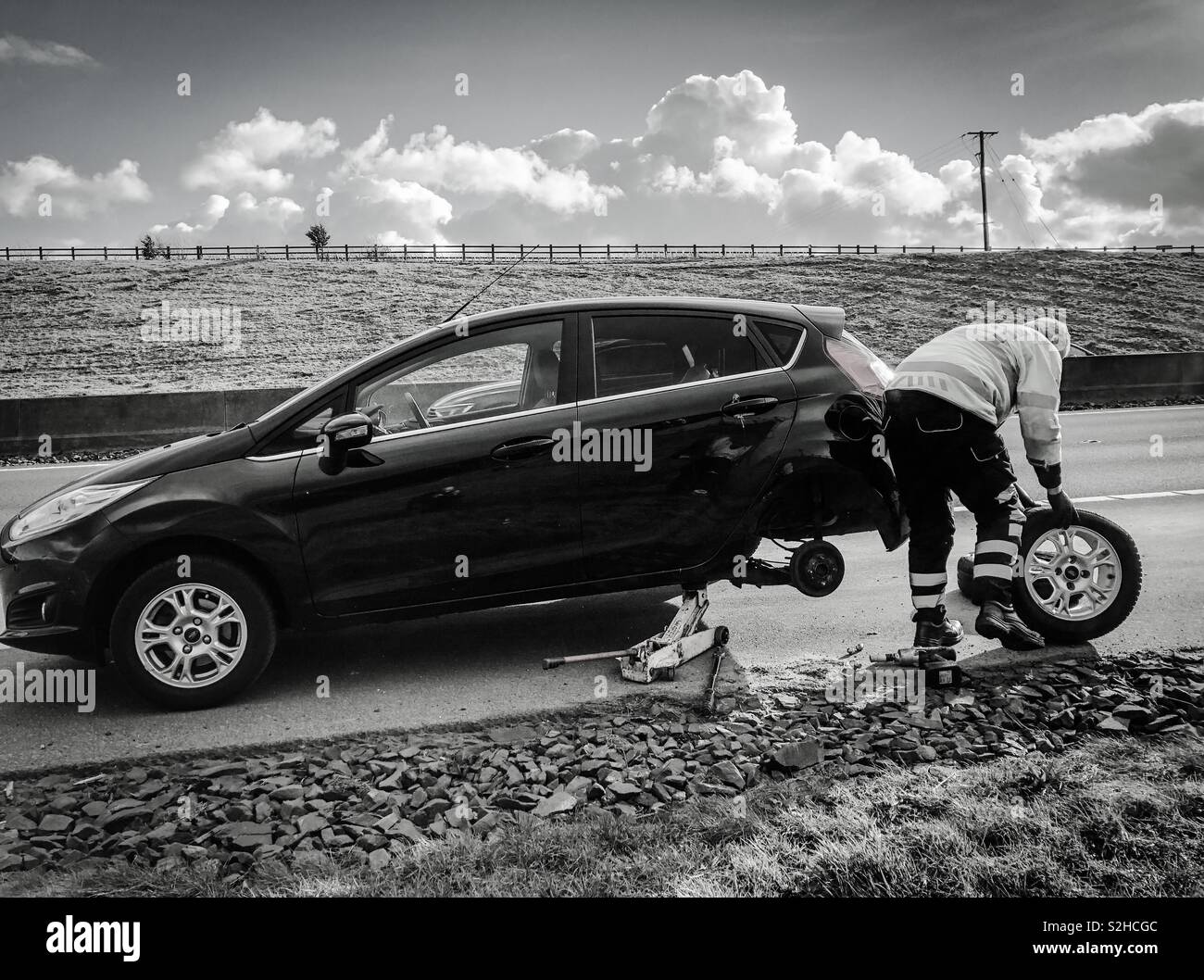 L'assistance routière. Changement de pneu sur disque mécanicien d'épaule d'autoroute M90. L'Écosse. UK. - Image de stock capturée avec un smartphone