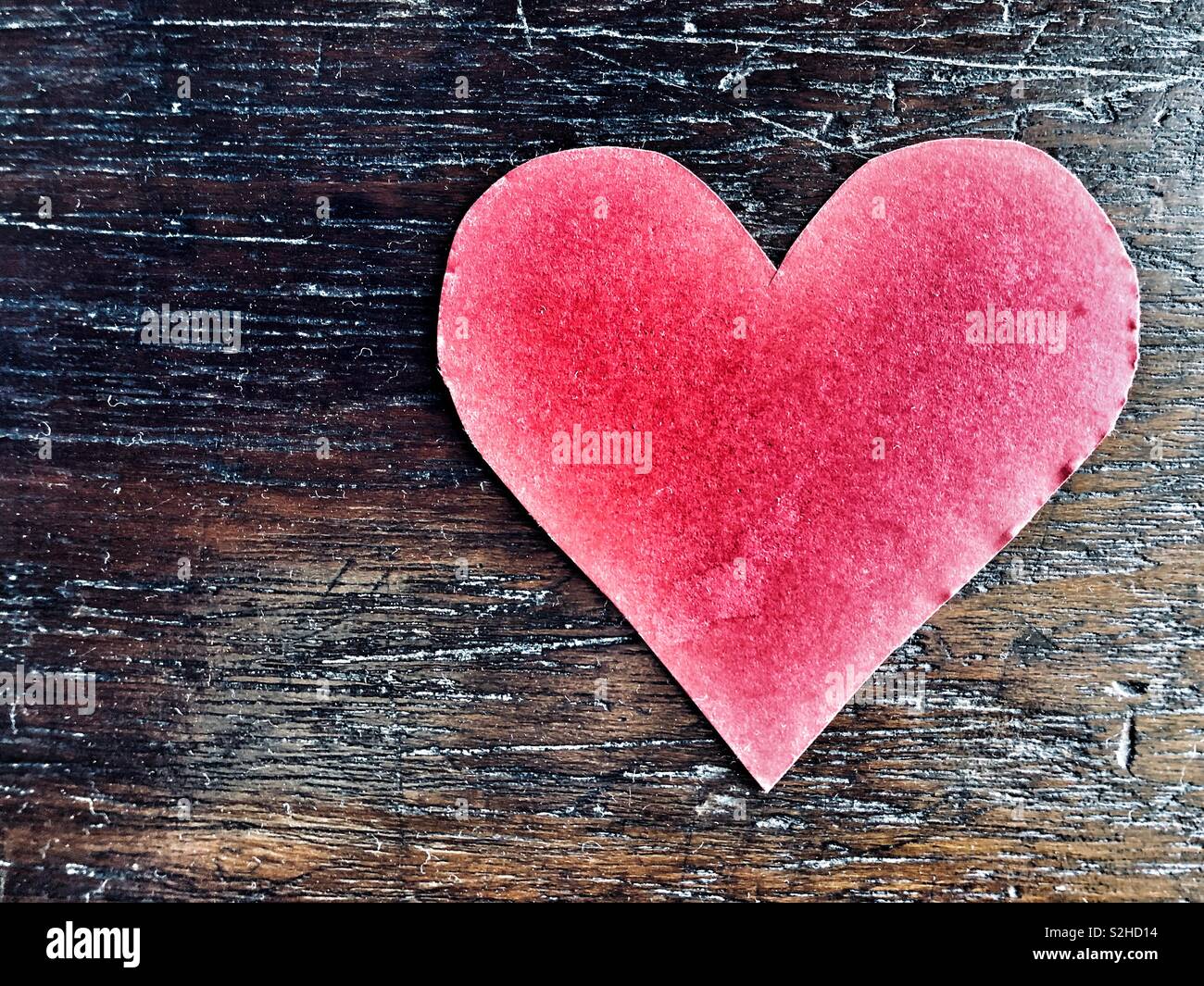 Cœur rouge sur fond de bois brun foncé - Image de stock capturée avec un smartphone