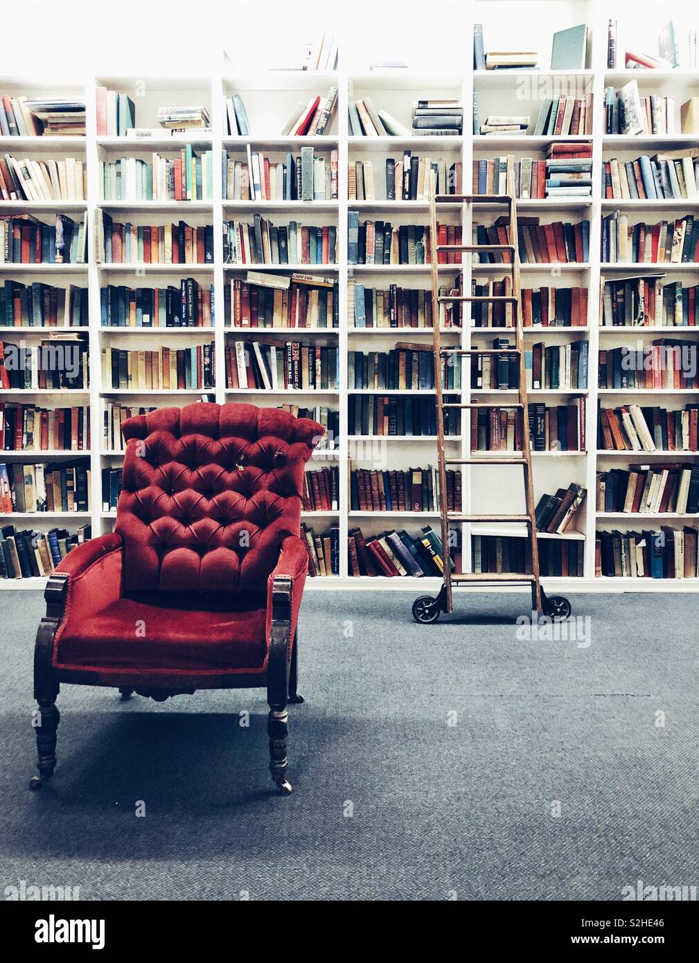 La bibliothèque de style vintage avec le matériel roulant et de l'échelle  chaise rouge Photo Stock - Alamy