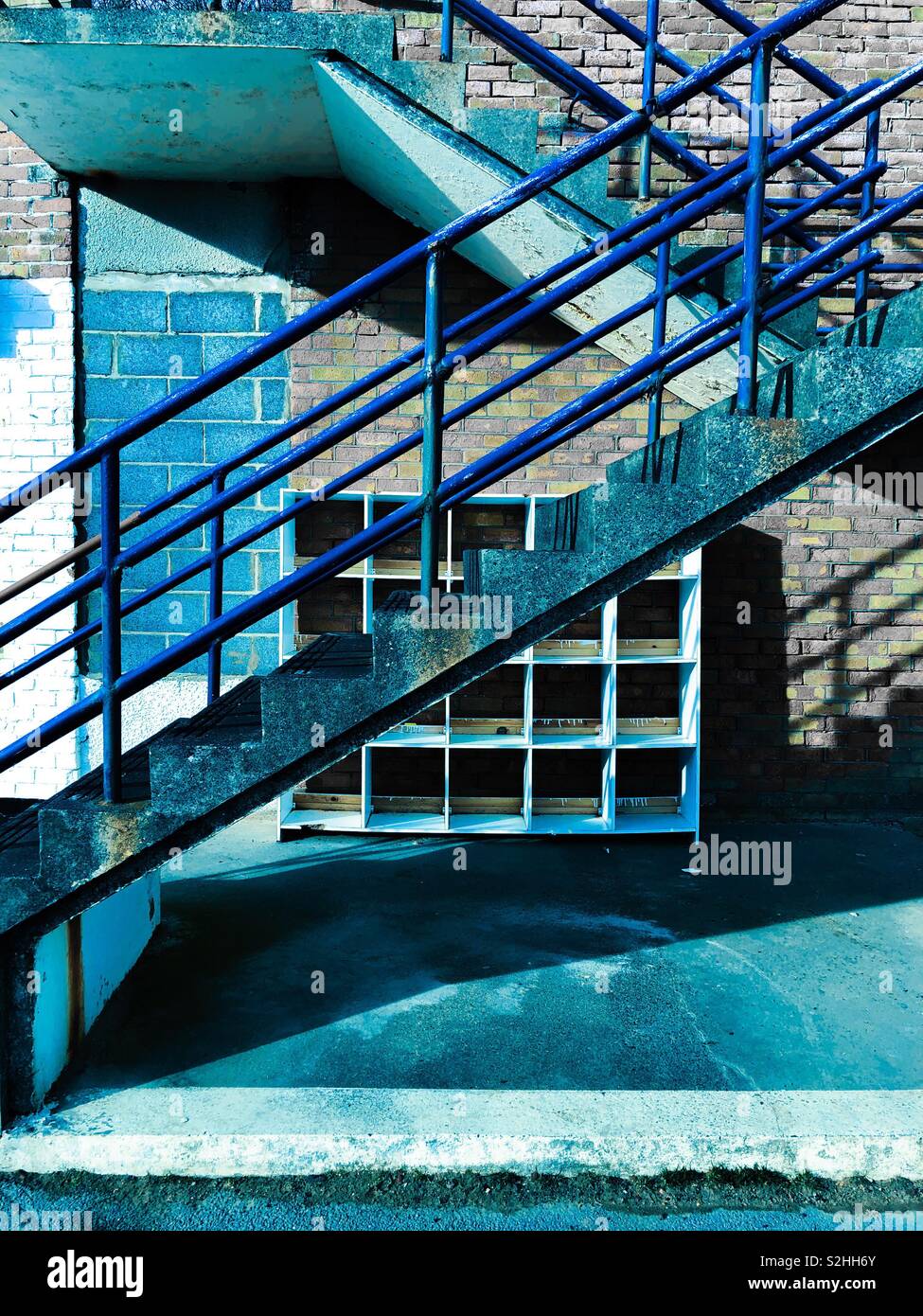 Résumé avec des tons bleus. Escalier extérieur et mélange de matériaux de construction et d'ombres. - Image de stock capturée avec un smartphone