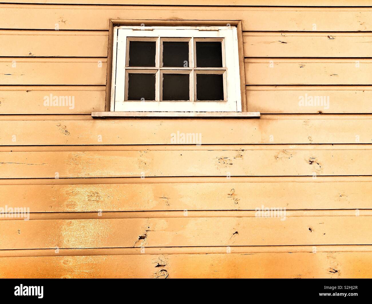 Fenêtre dans un bâtiment en bois éclairé par la lumière du soleil du matin. Banque D'Images