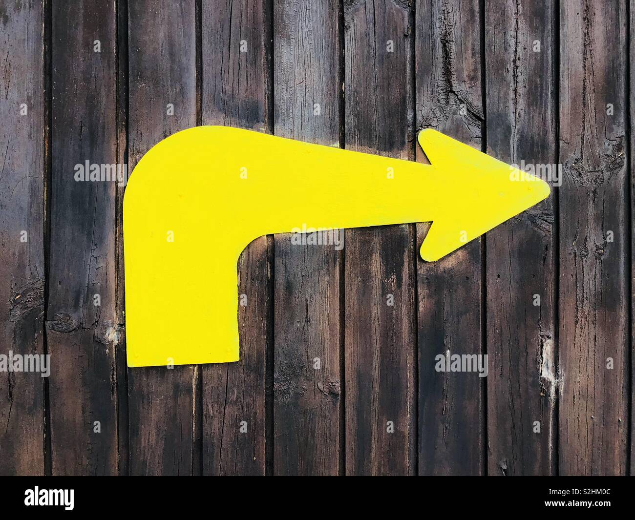 Flèche jaune sur la construction en bois Banque D'Images