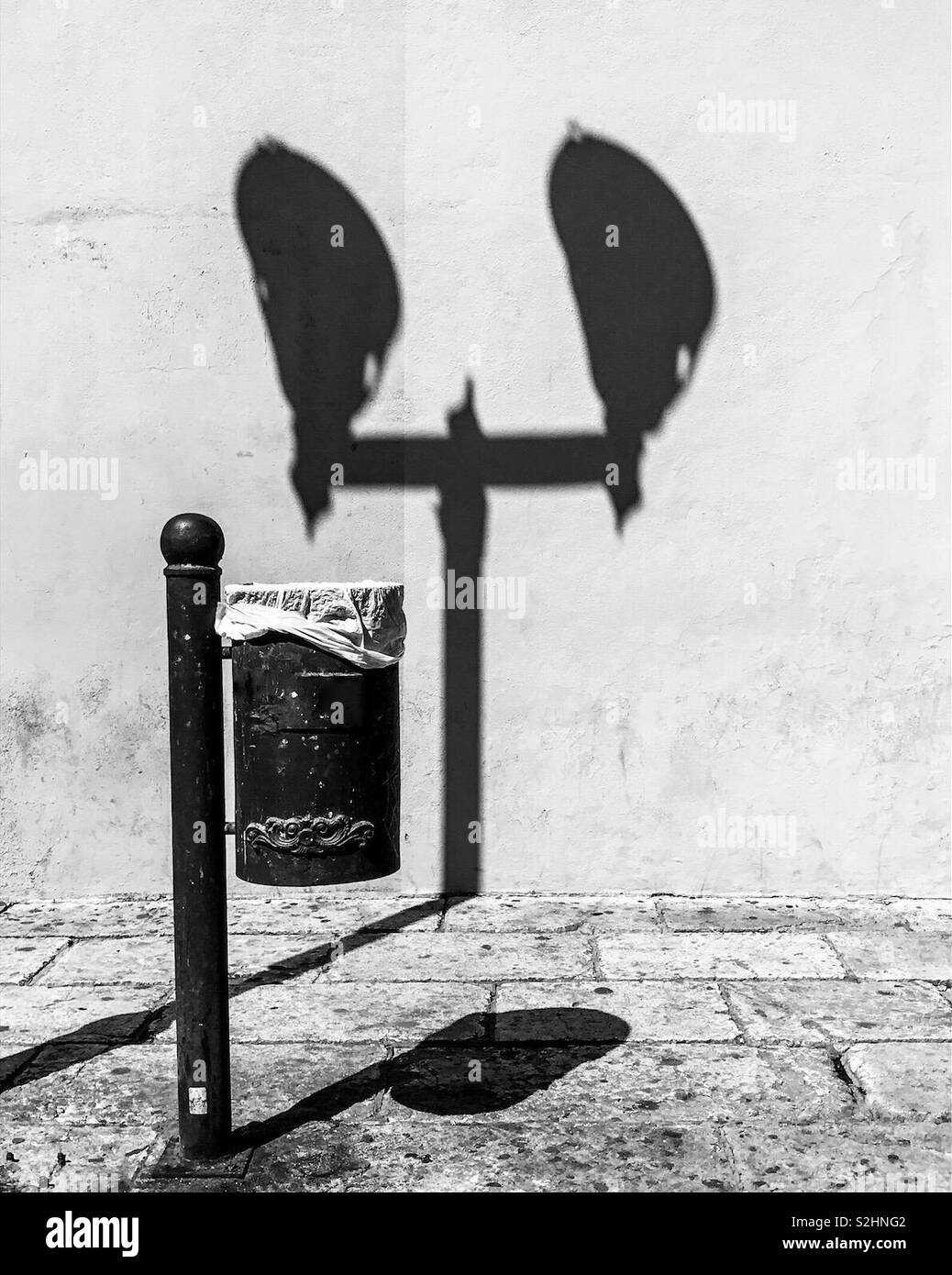 Ombre délicate. Corbeille contre le mur avec une ombre de lumières de rue pôle. Noir et blanc. Oaxaca de Juarez, Oaxaca, Mexique. 16 février 2019 Banque D'Images