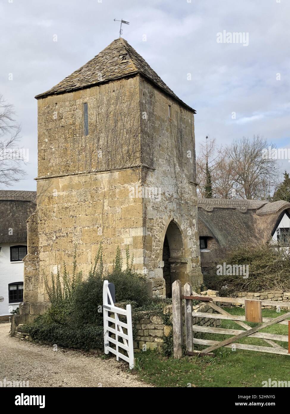 Ruine pittoresque tour et tout ce qui est à gauche de l'église médiévale à Gretton, près de Cheltenham dans le Vale of Evesham flanquée de magnifique chaumières. - Image de stock capturée avec un smartphone