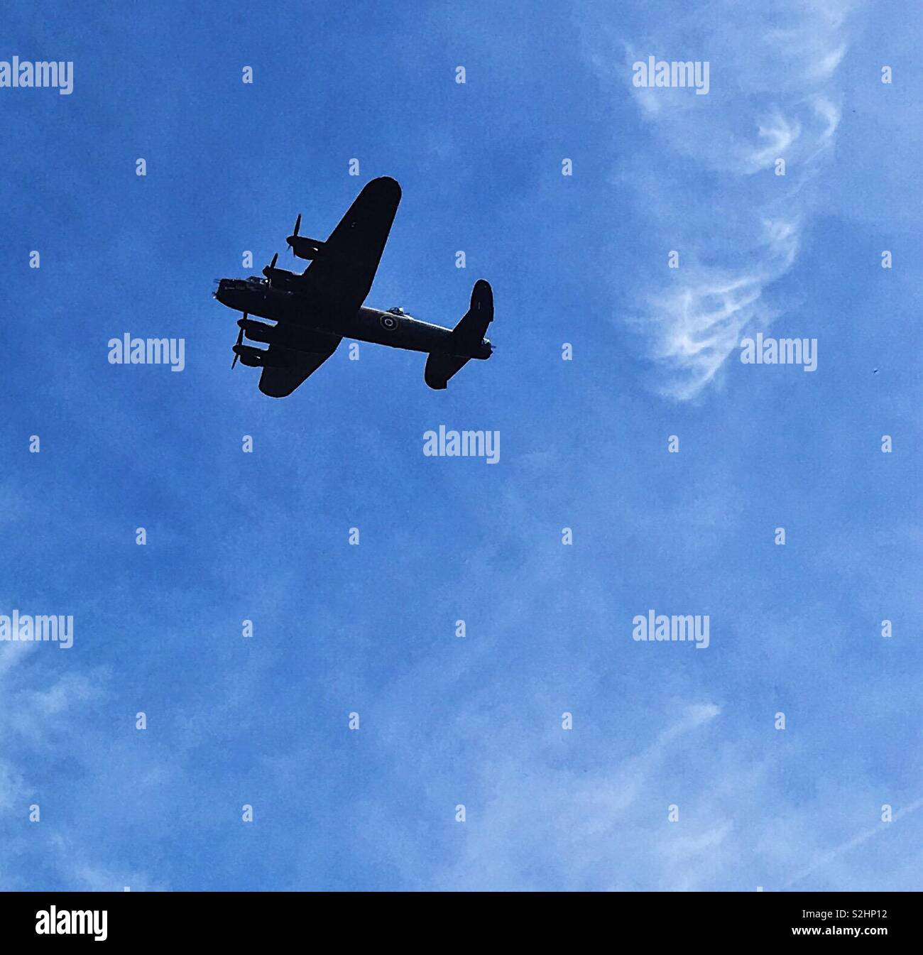 Bombardier Lancaster en vol silhouetté contre le ciel bleu. Banque D'Images