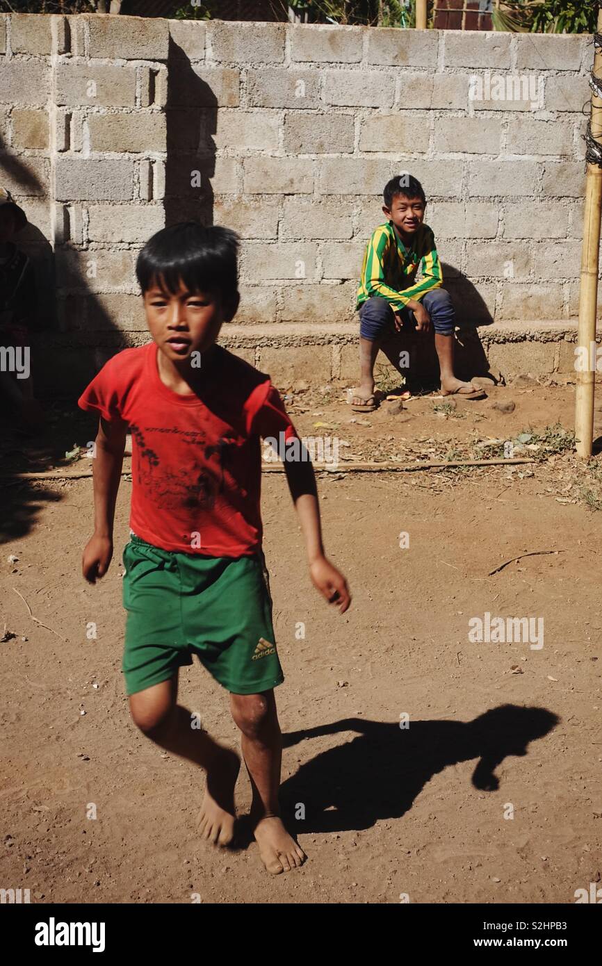 Les enfants birmans, les petits garçons, jouer au ballon dans le sable Banque D'Images