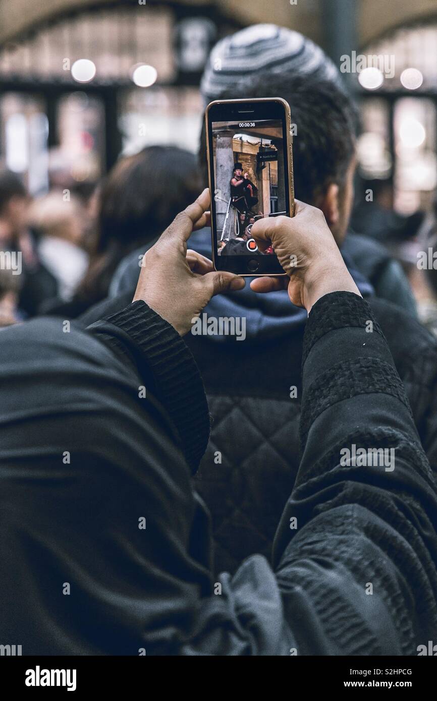 Artiste de rue d'enregistrement personne sur son téléphone à une foule Banque D'Images