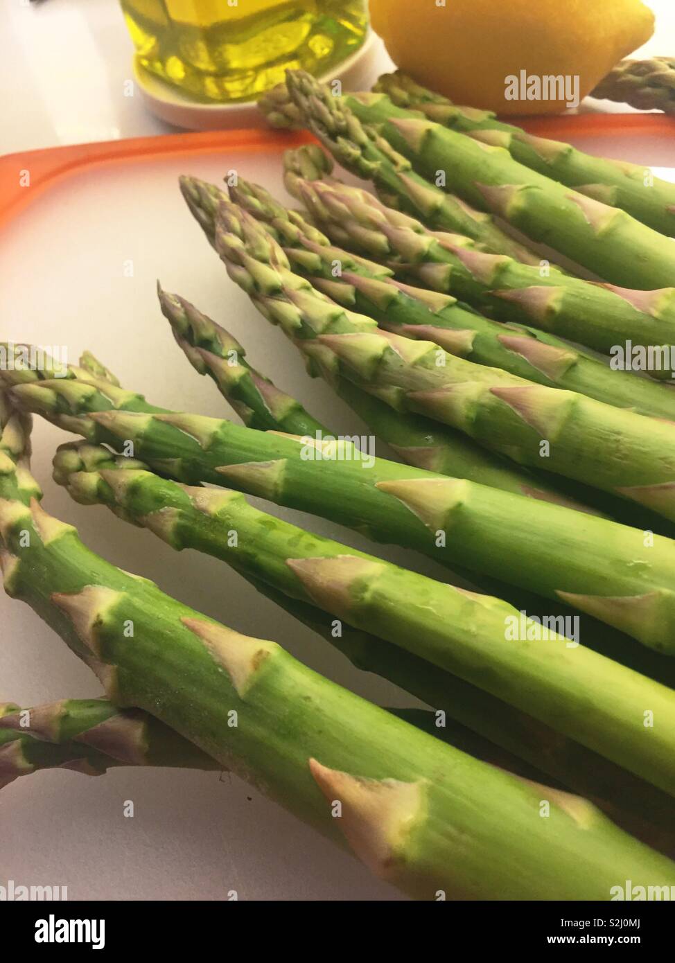 Les frais d'asperge sur une table de préparation découper avec de l'huile d'olive et citron - Image de stock capturée avec un smartphone