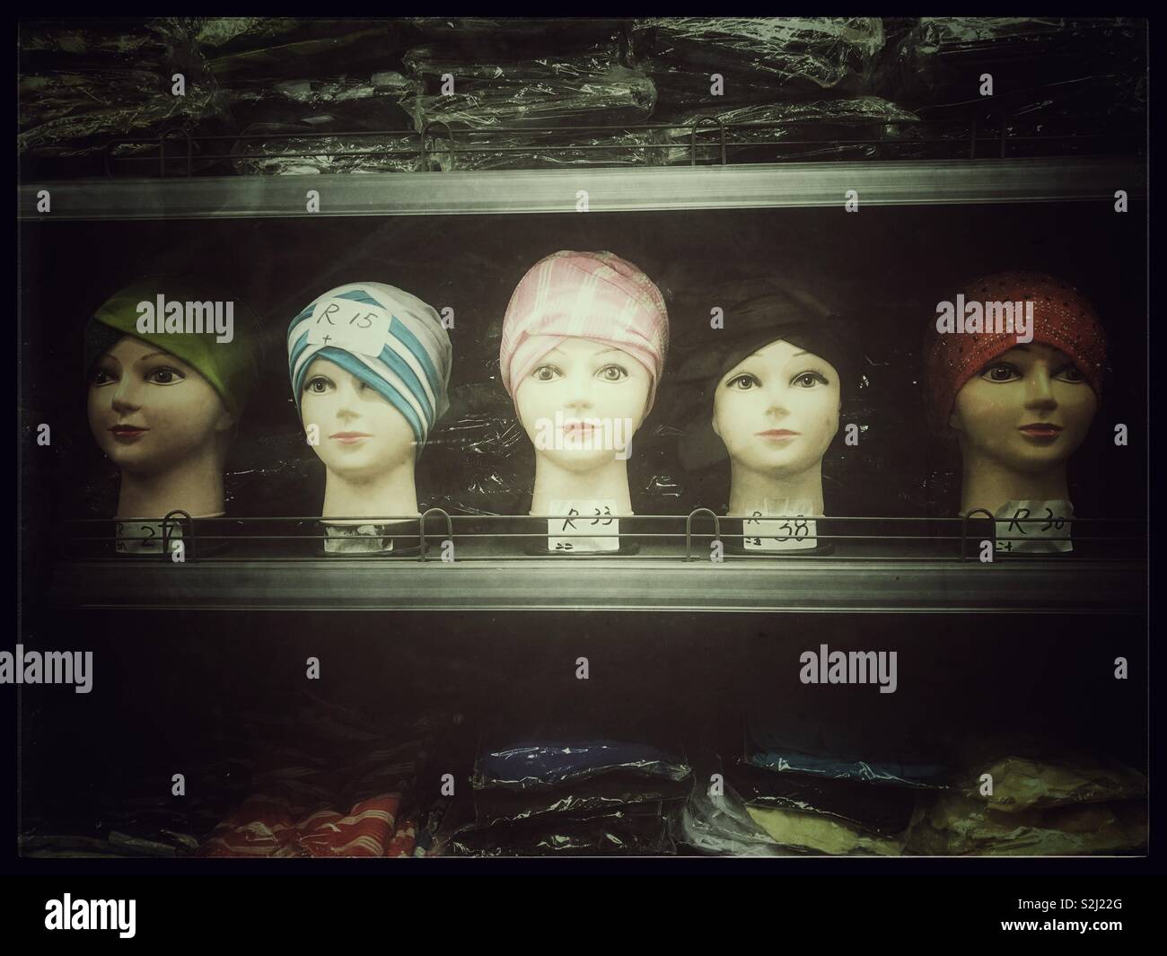 Rangée de têtes de mannequins avec des chapeaux à la vente. Banque D'Images