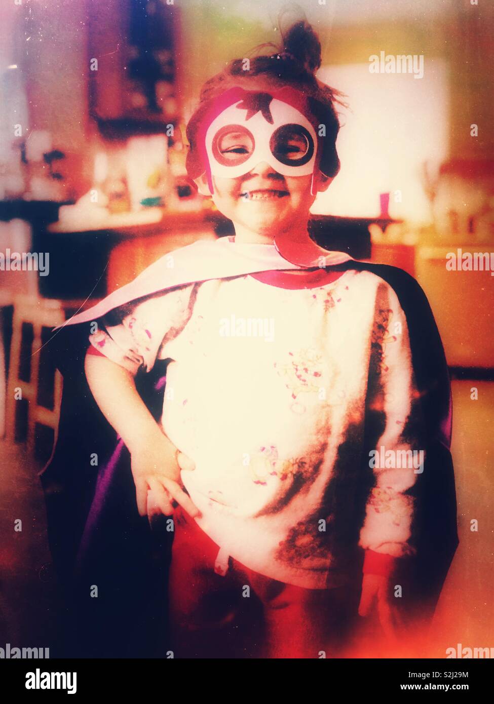 3 ans, fille habillé en super héros et souriant Banque D'Images