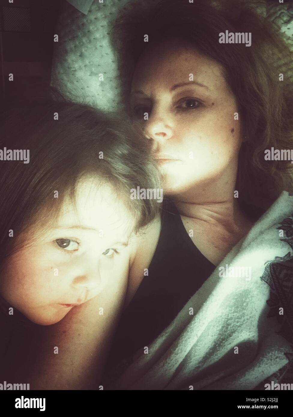 La mère et l'enfant avec l'expression craintive together in bed Banque D'Images