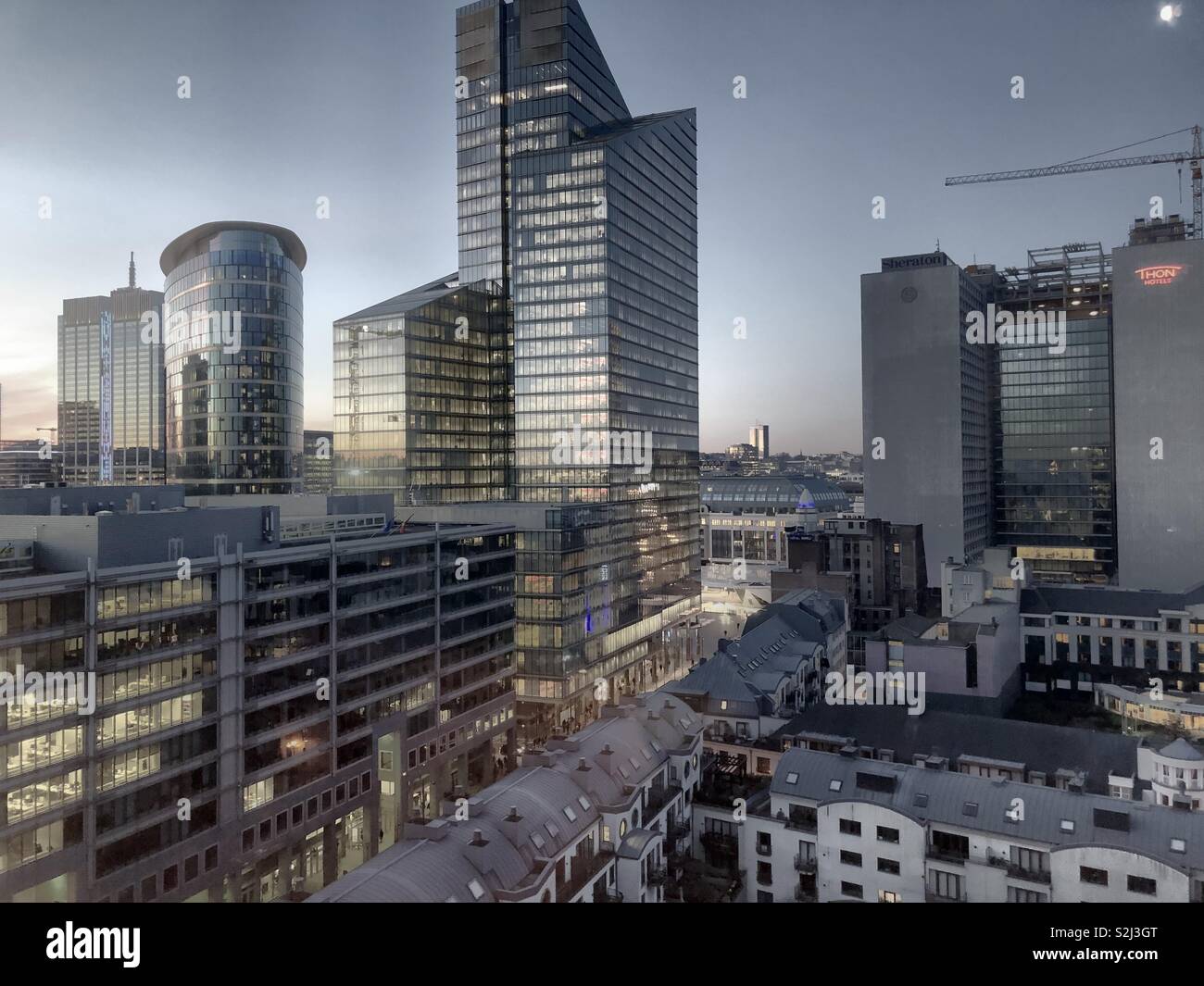 Une palette complète de couleurs au lever du soleil, illustré dans le ciel et le reflet du ciel dans le verre des bureaux d'affaires du quartier financier de la ville - Image de stock capturée avec un smartphone