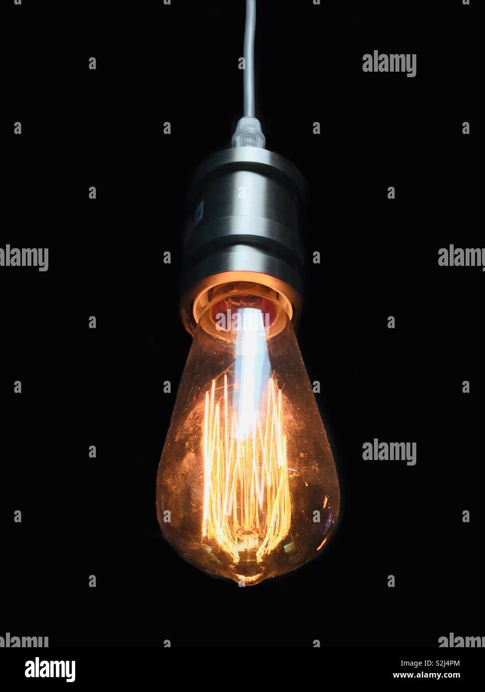 Ampoule ancienne pende pas d'abat-jour et lumineux brillant - Image de stock capturée avec un smartphone