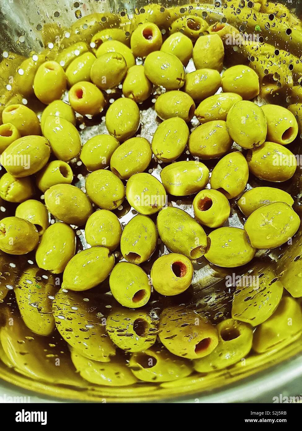 Olives vertes dans une passoire avec réflexion - Image de stock capturée avec un smartphone