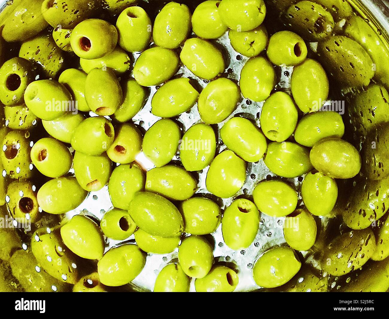 Olives vertes dans une passoire avec réflexion - Image de stock capturée avec un smartphone