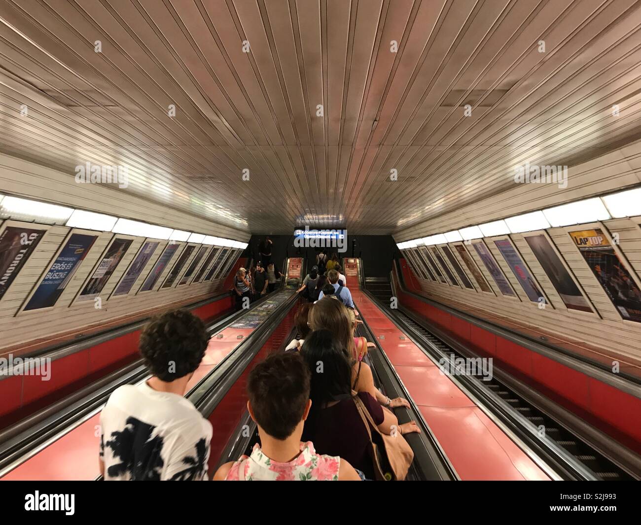 Budapest, Hongrie - 14 juin 2017 : pour les usagers du transport en commun, descendre une pente raide, long escalier roulant à l'arrêt de métro de la Place Deak Ferenc. Les lignes de métro 1, 2 et 3 se croisent à cette station de transfert. - Image de stock capturée avec un smartphone