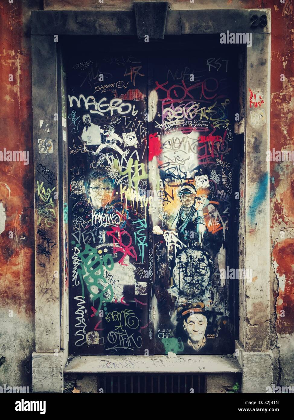 Une porte couverte de graffiti et street art stencil à Rome Photo Stock -  Alamy