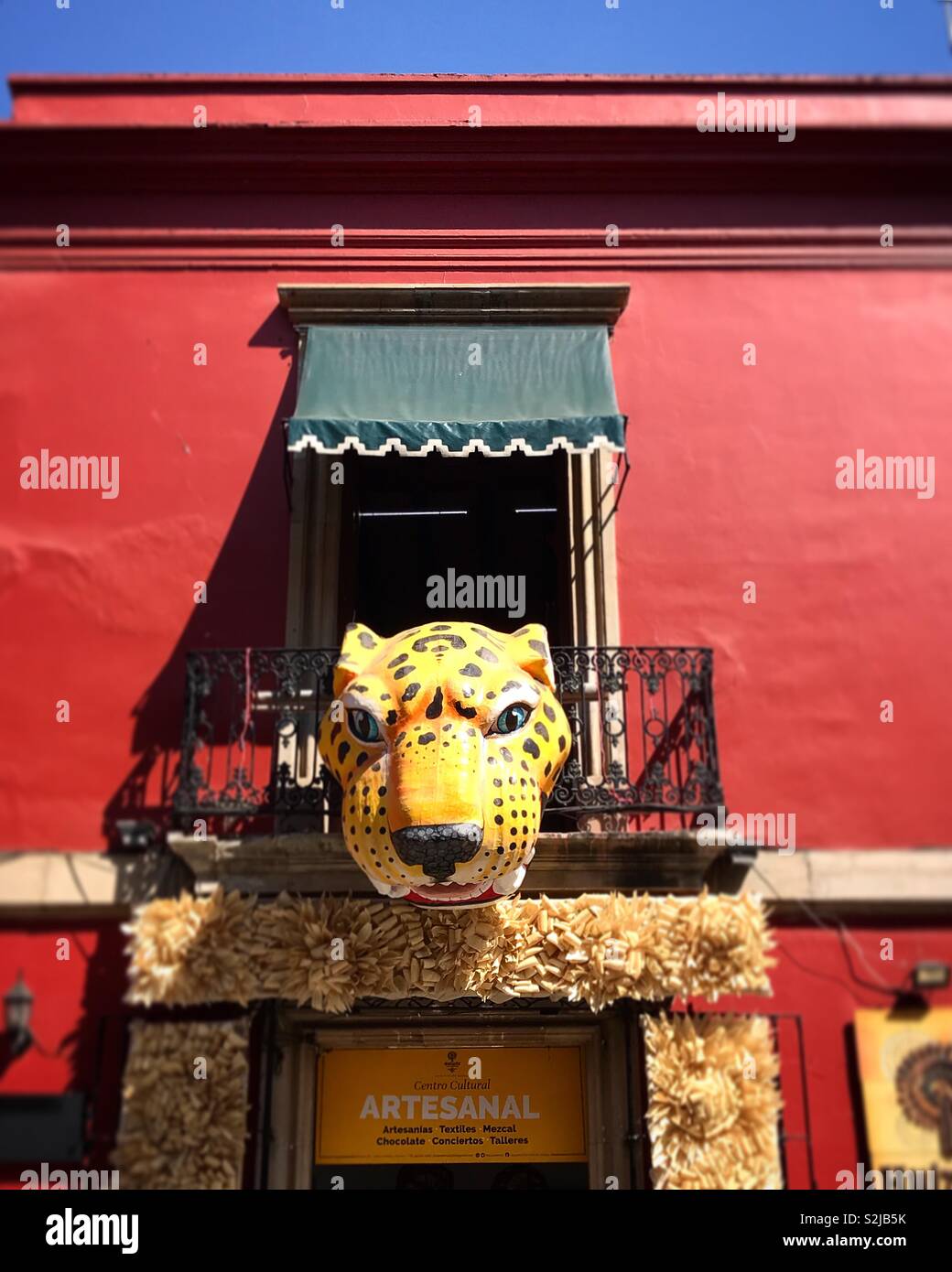 Une tête d'un jaguar rouge décore un édifice colonial dans le centre-ville d'Oaxaca, Mexique Banque D'Images