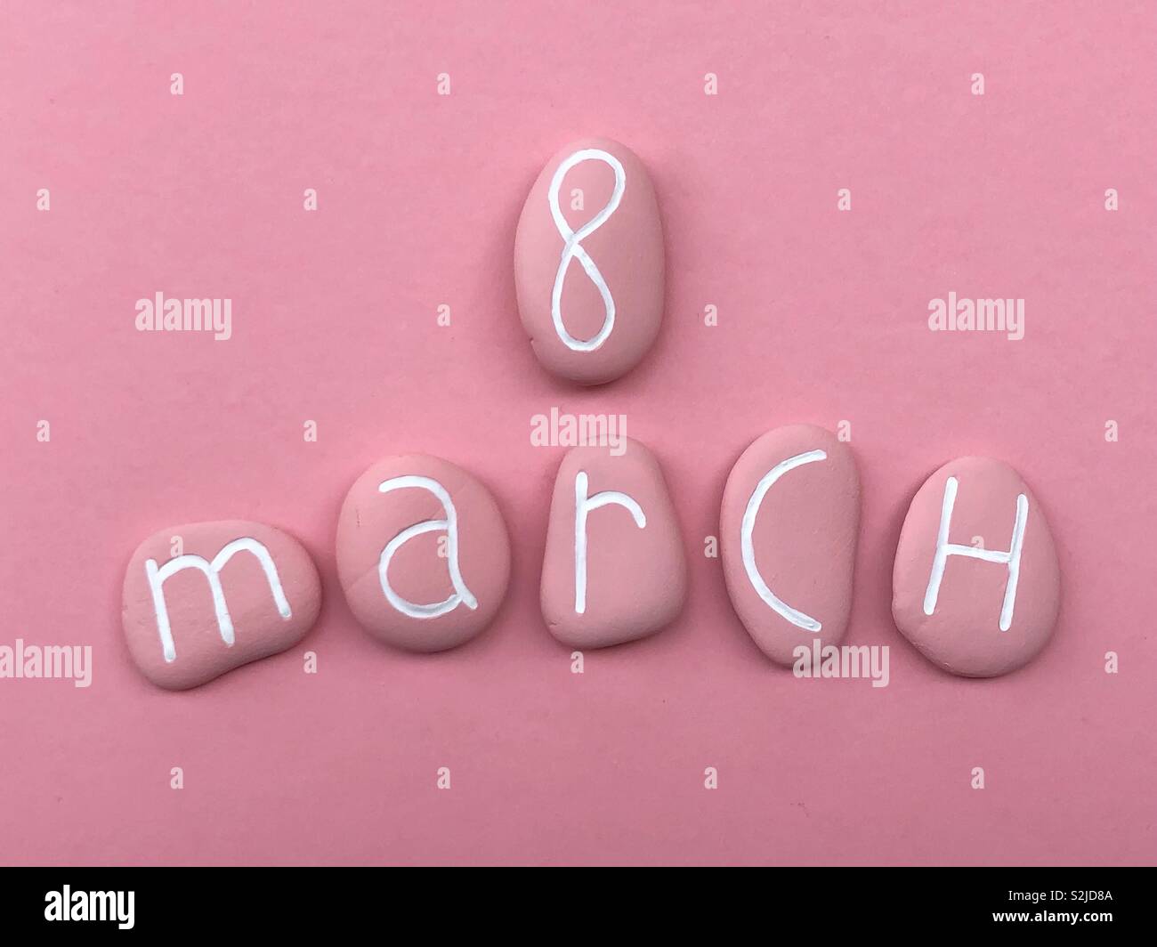 8 mars, Journée des femmes, célébrée par des pierres de couleur rose sur fond rose Banque D'Images