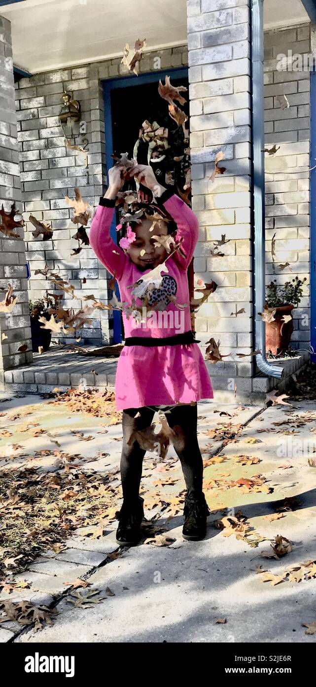Girl throwing leafs dans l'air. Banque D'Images