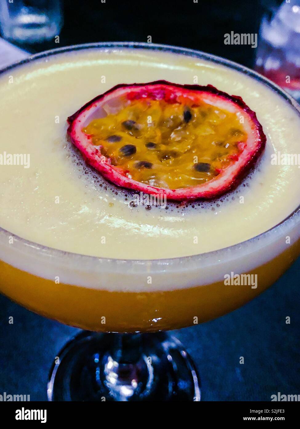 Stars martini. Vodka, purée de fruits de la passion, le sucre et le jus d'orange, servi avec une tranche de fruit de la passion. Banque D'Images