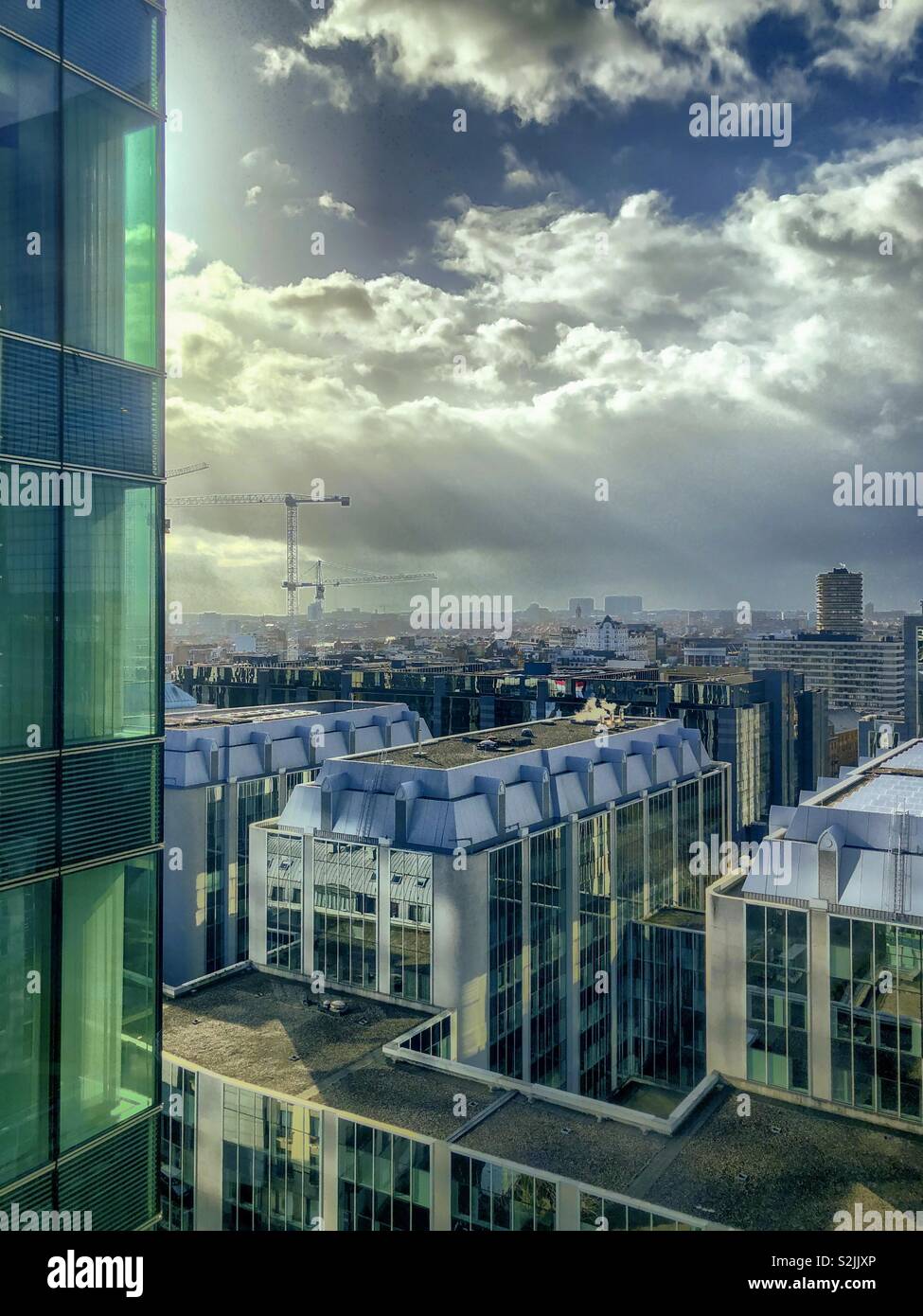 Rayons de soleil percent l'épais nuages sur les bureaux du quartier des affaires de la ville de Bruxelles - Image de stock capturée avec un smartphone
