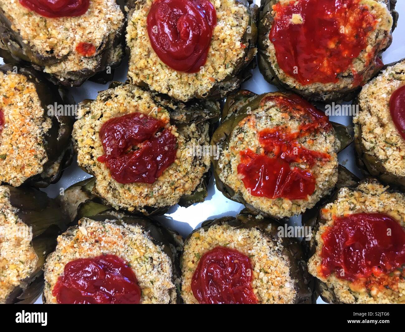 Artichauts farcis italien sicilien fait maison avec de la panure assaisonnée et ketchup comme garniture. Banque D'Images