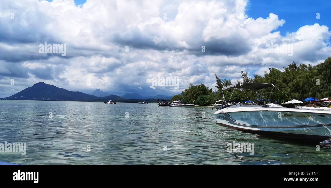 Ciel nuageux sur les montagnes et les bateaux amarrés au rivage de l'île aux bénitiers en France Banque D'Images