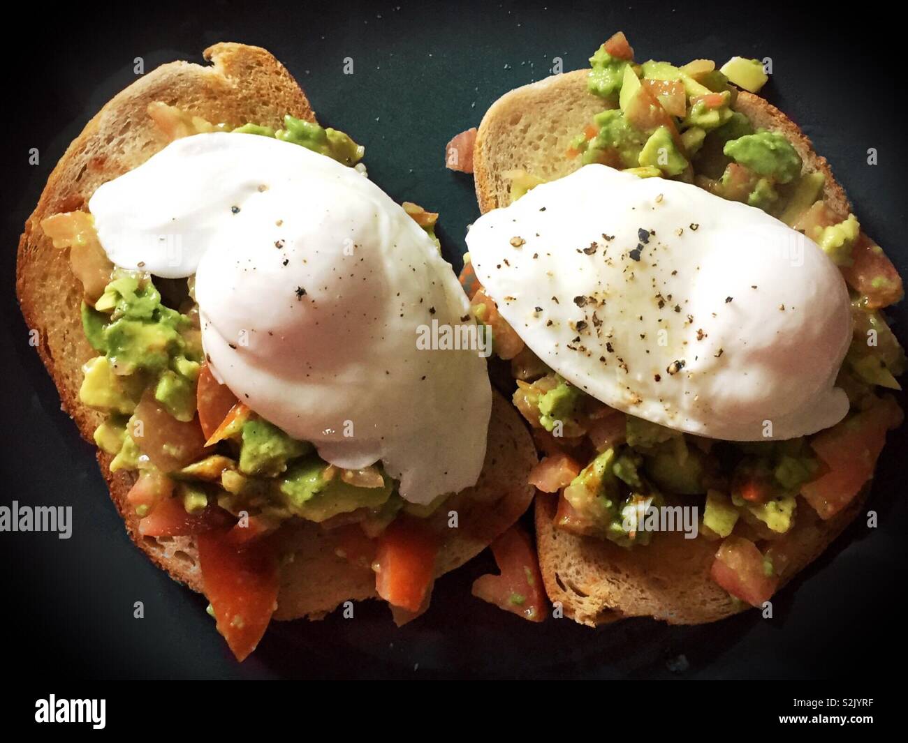 Toast avocat. Manger santé propre à la pause déjeuner ou petit-déjeuner faite avec des œufs et des tomates. Les protéines et l'alimentation végétarienne. La perte de poids et se sentir plein. Pain au levain Banque D'Images