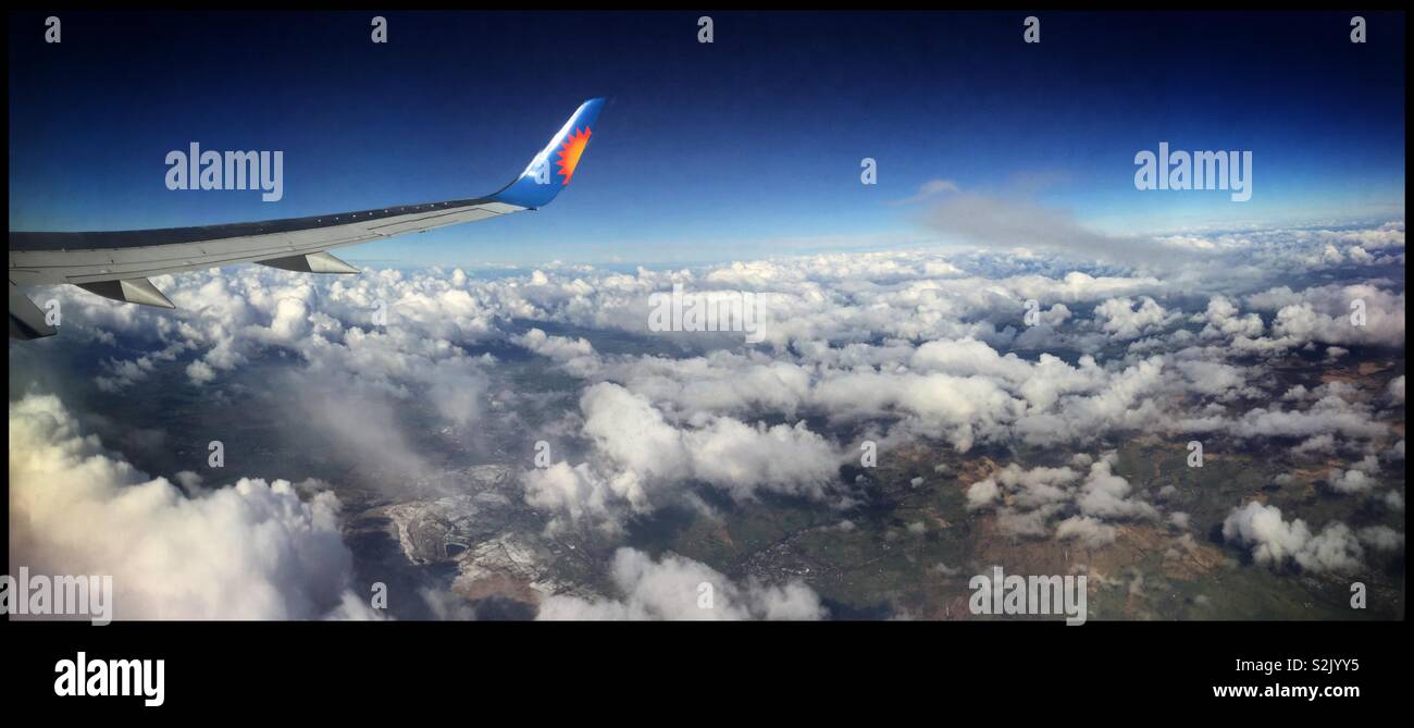 Vue au-dessus des nuages sur le siège 26F sur un Jet2 avion venant de l'aéroport de Leeds Bradford (Royaume-Uni) à l'aéroport de Barcelone El Prat, Espagne. - Image de stock capturée avec un smartphone