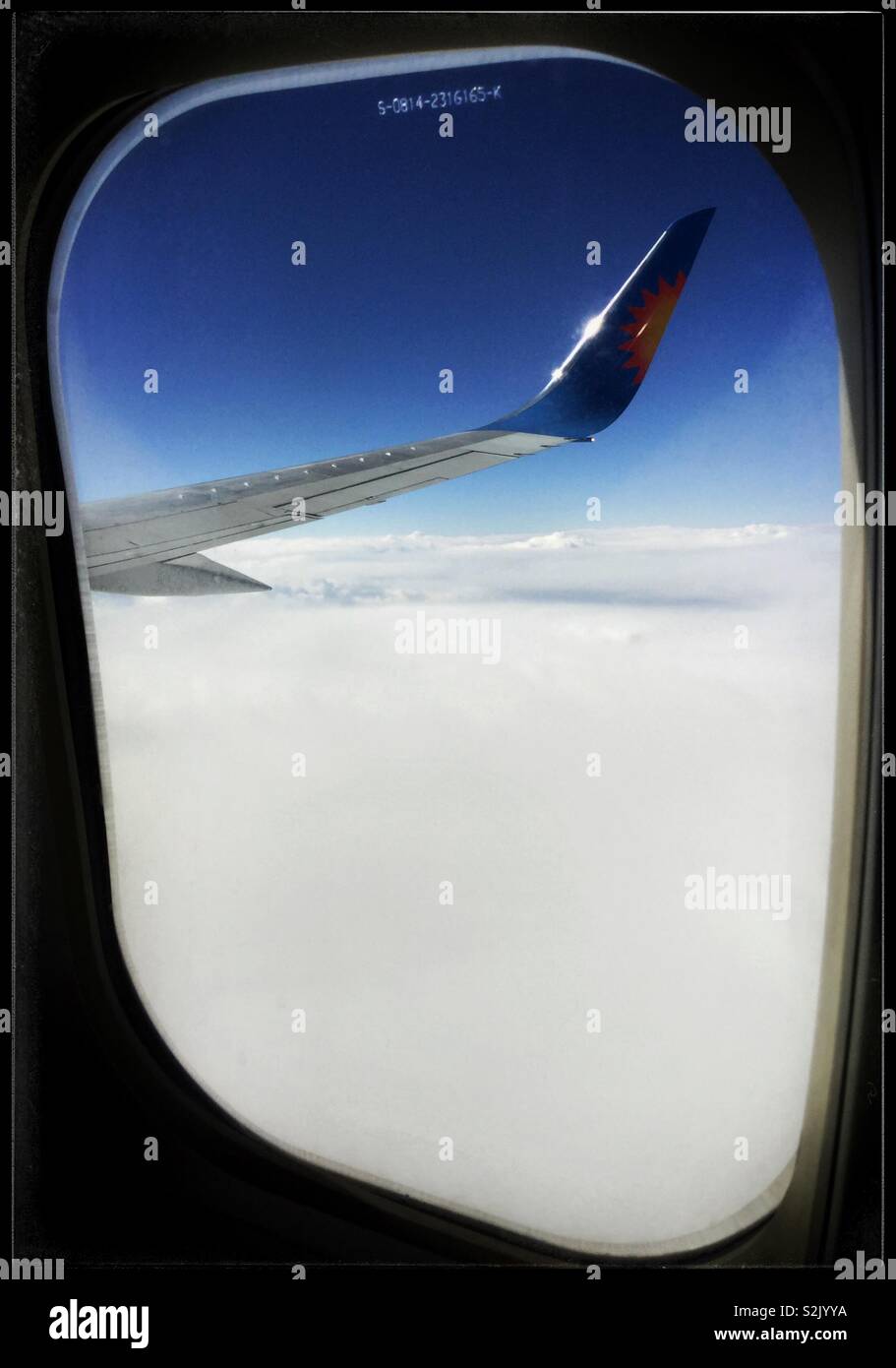 Vue au-dessus des nuages sur le siège 26F sur un Jet2 avion venant de l'aéroport de Leeds Bradford (Royaume-Uni) à l'aéroport de Barcelone El Prat, Espagne. - Image de stock capturée avec un smartphone