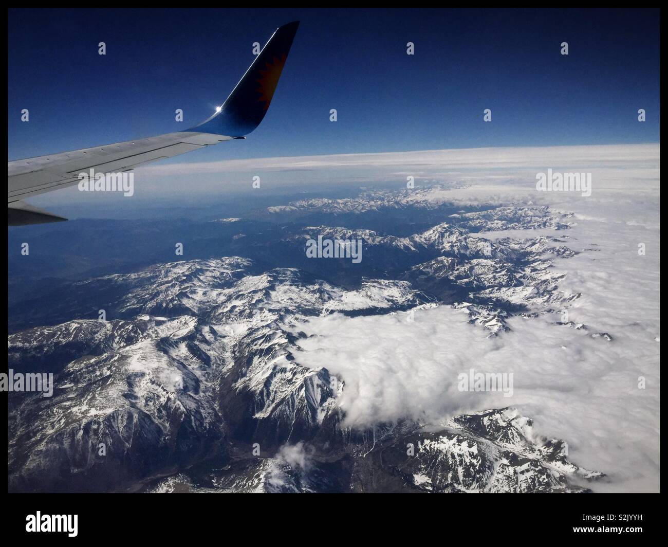 Vue au-dessus des nuages sur les Pyrénées depuis le siège 26F sur un Jet2 avion venant de l'aéroport de Leeds Bradford (Royaume-Uni) à l'aéroport de Barcelone El Prat, Espagne. - Image de stock capturée avec un smartphone
