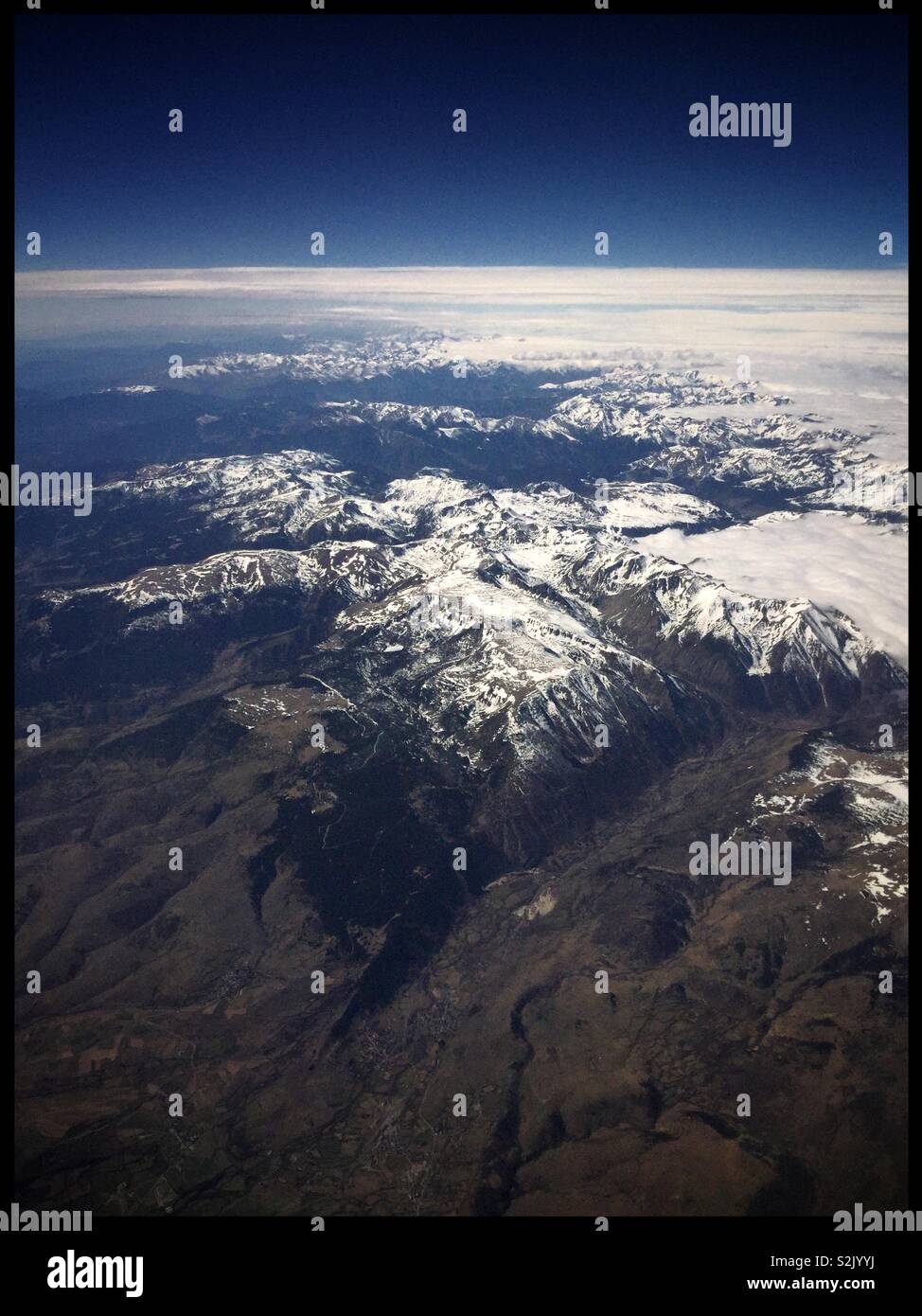 Vue au-dessus des nuages sur les Pyrénées depuis le siège 26F sur un Jet2 avion venant de l'aéroport de Leeds Bradford (Royaume-Uni) à l'aéroport de Barcelone El Prat, Espagne. - Image de stock capturée avec un smartphone