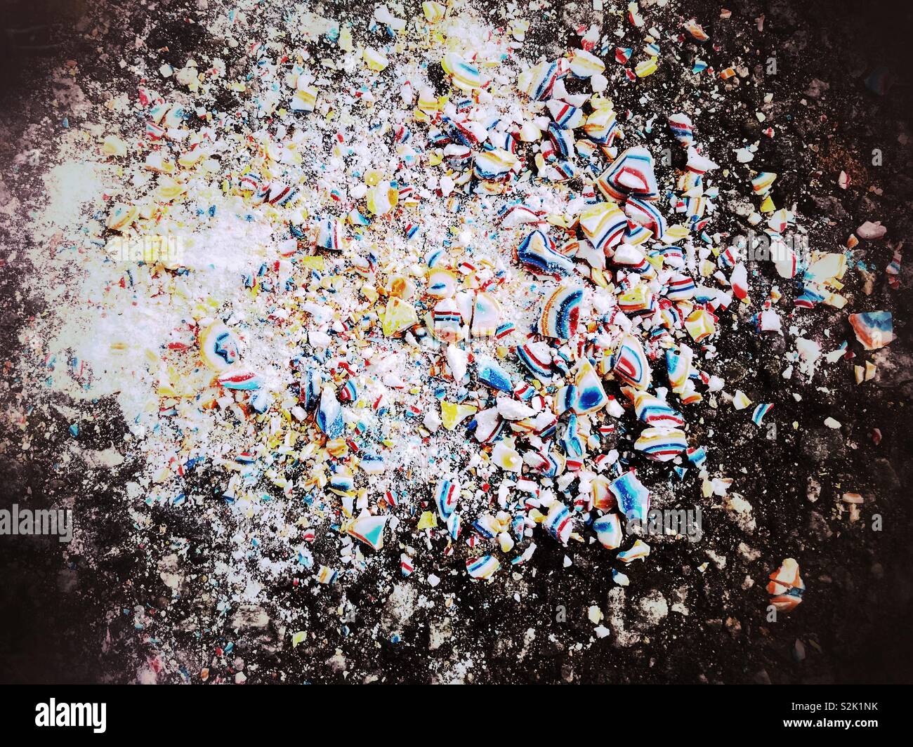Jawbreaker sur trottoir, broyée en morceaux colorés Banque D'Images
