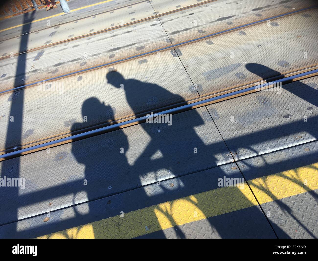 Silhouettes d'un couple de prendre une photo de son ombre au soleil, sur le rail road. Banque D'Images