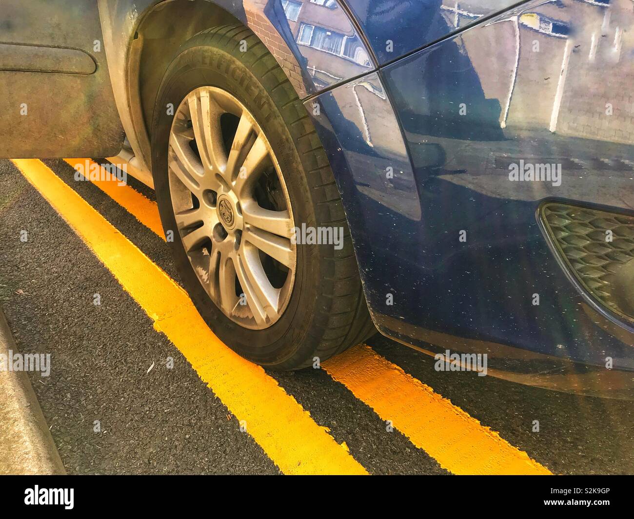 Une voiture stationnée illégalement sur le double lignes jaunes. - Image de stock capturée avec un smartphone