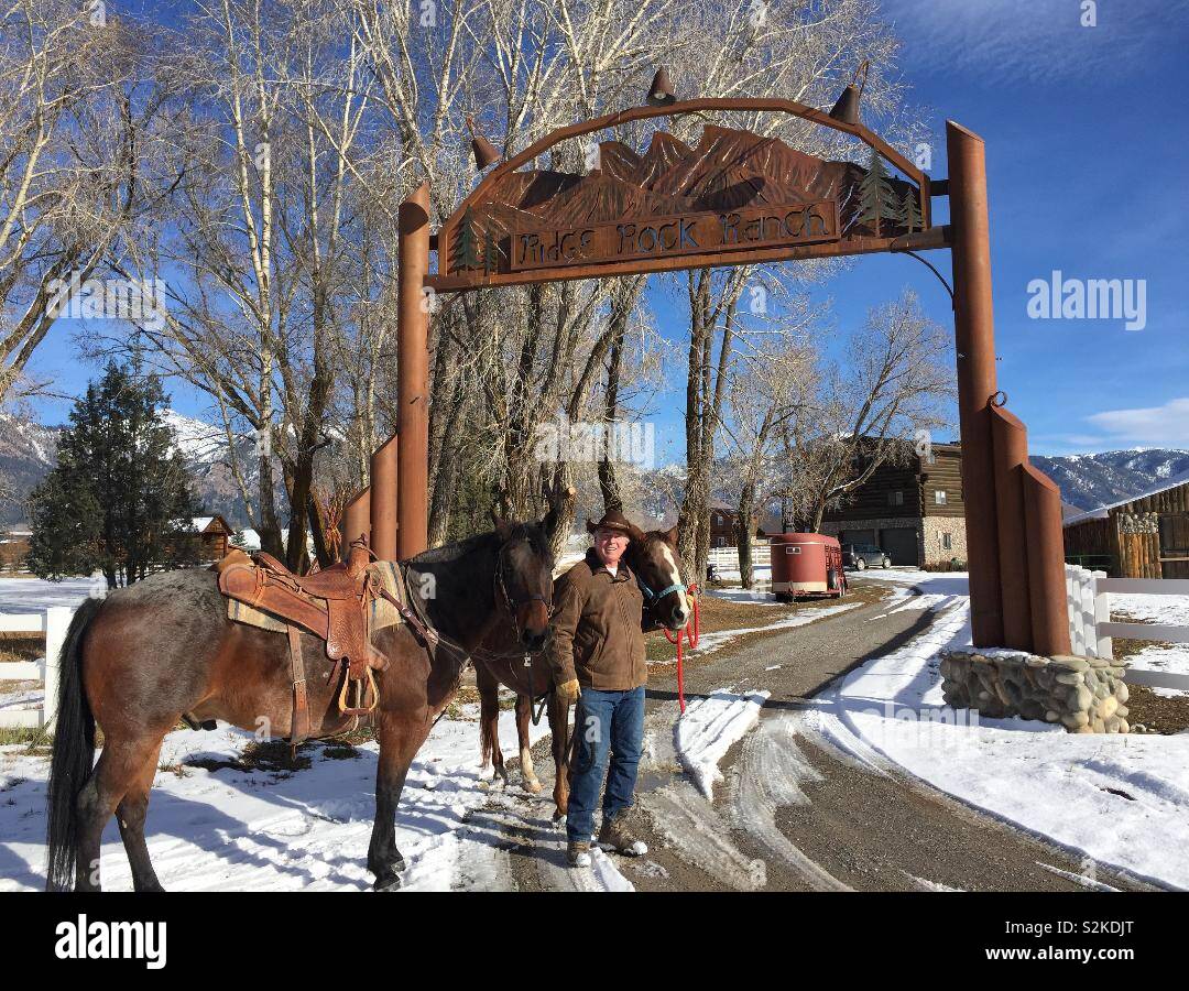 Un propriétaire de ranch du Wyoming fièrement avec ce cheval à son entrée dans son ranch Banque D'Images