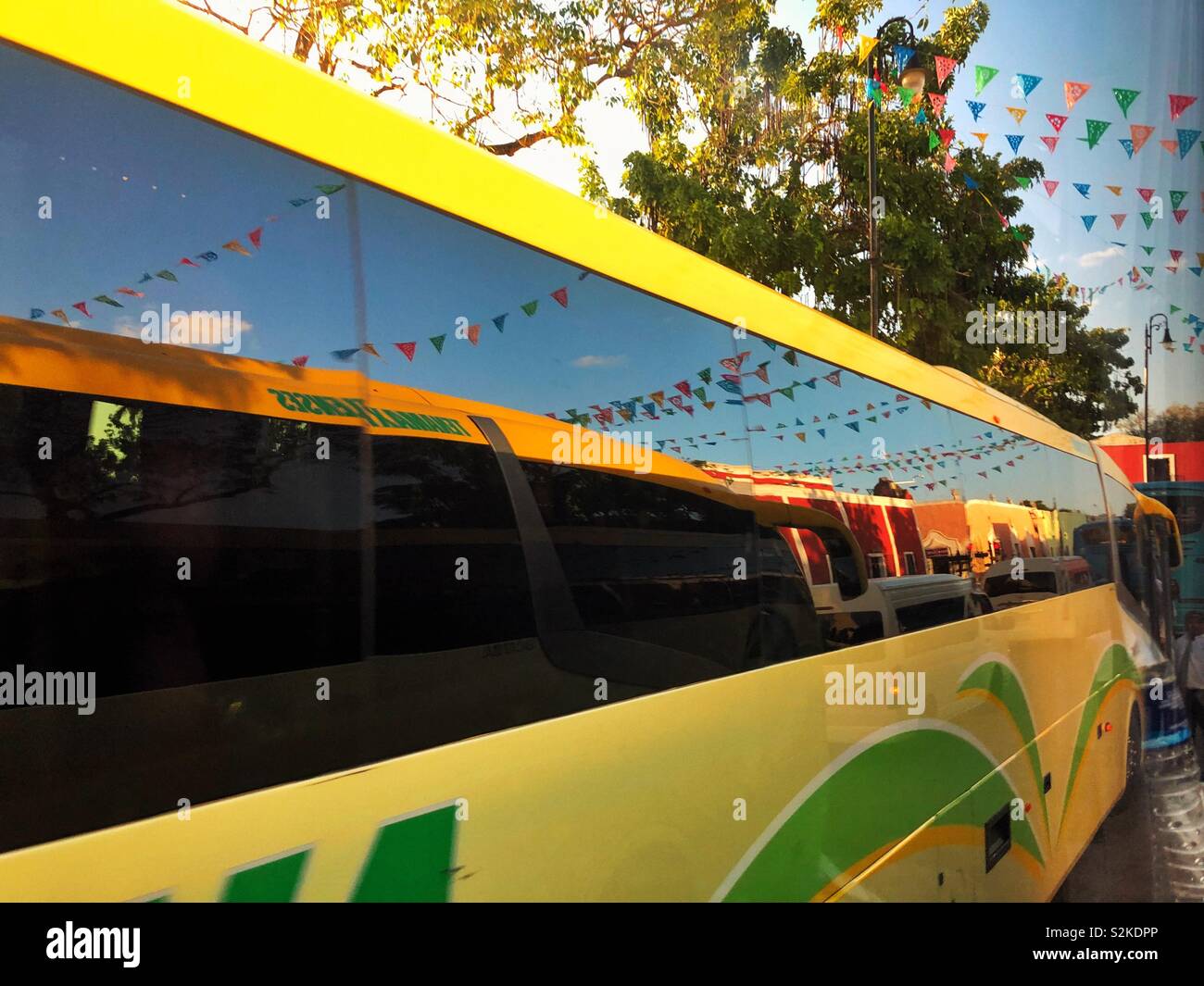 Papel picado traditionnels drapeaux en papier décorer street à Valladolid et reflètent en tour bus windows Banque D'Images