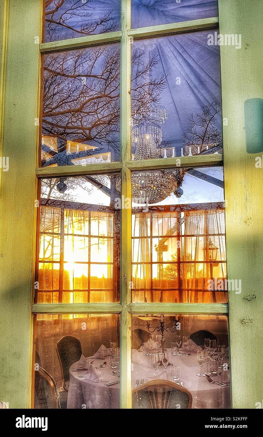 Voir à travers les fenêtres de la salle à manger privée avec lustre au coucher du soleil, Stockholm, Suède, Scandinavie Banque D'Images