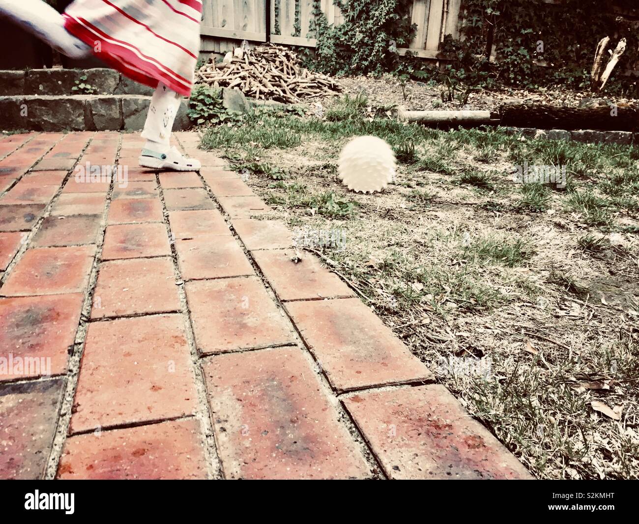 Petite fille à jouer au ballon dans une cour arrière. Banque D'Images