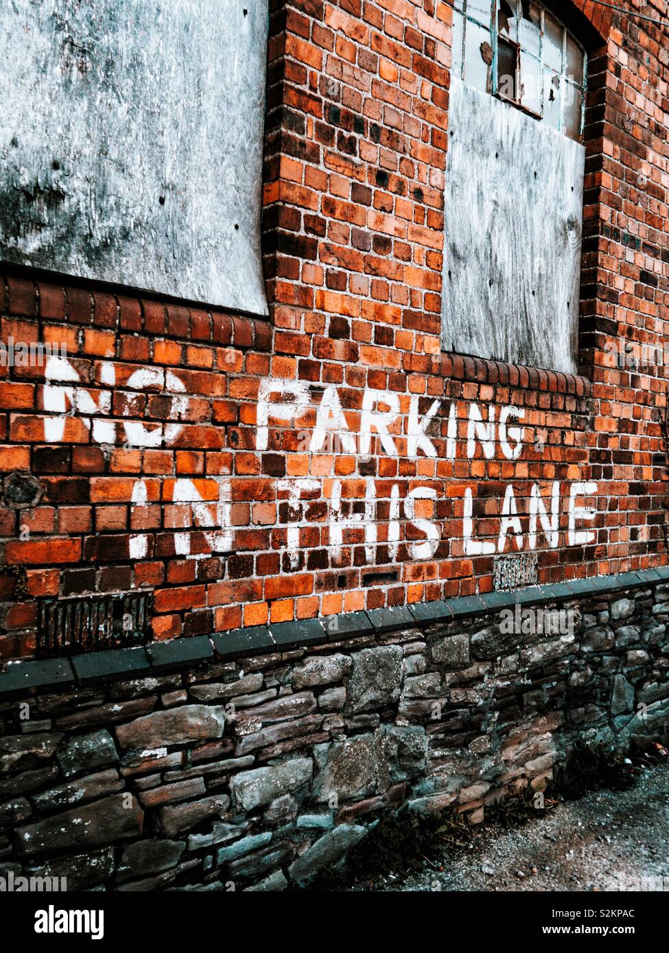 Pas de parking dans cette ruelle écrit sur un vieux mur de brique rouge Banque D'Images