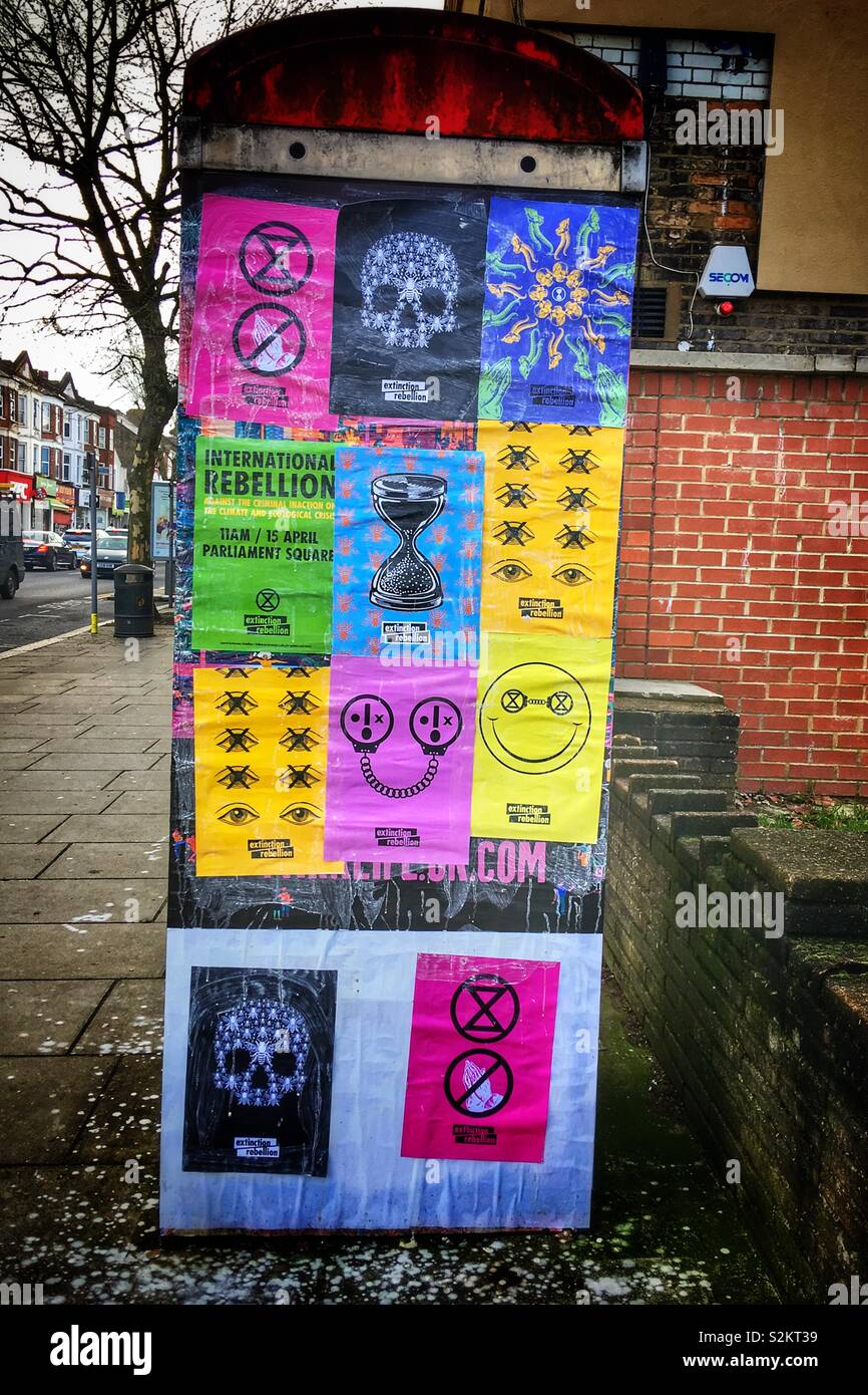 Rébellion d'extinction les changements climatiques sur des affiches de protestation dans une cabine téléphonique East Finchley - Image de stock capturée avec un smartphone