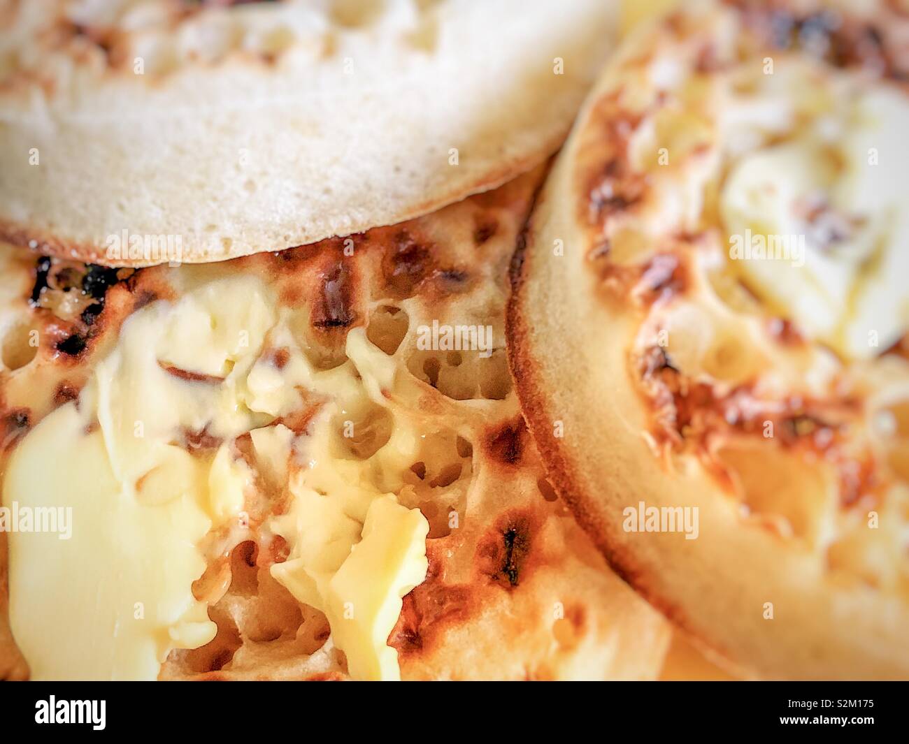 Faire fondre le beurre avec les crumpets chauds. Banque D'Images