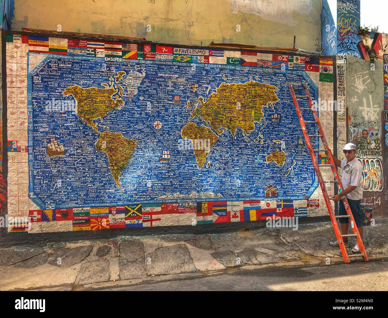 Une fresque de la carte du monde avec les noms des personnes vivant dans les favelas de Rio de Janeiro, Brésil. - Image de stock capturée avec un smartphone
