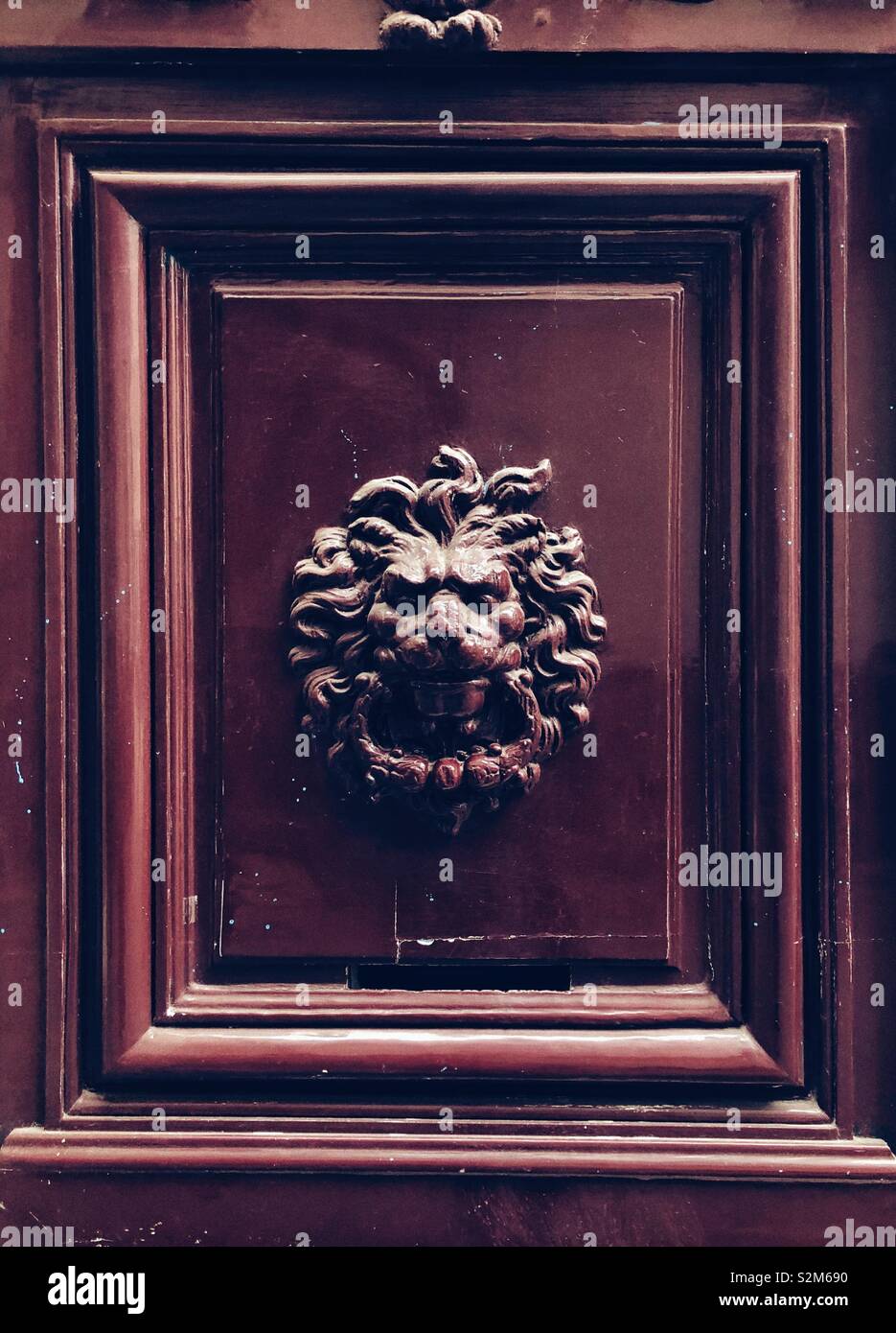 Heurtoir en forme de tête de lion sur la porte rouge, à Paris - Image de stock capturée avec un smartphone