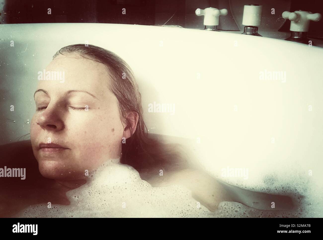 Woman relaxing in bubble bath avec les yeux fermé Banque D'Images