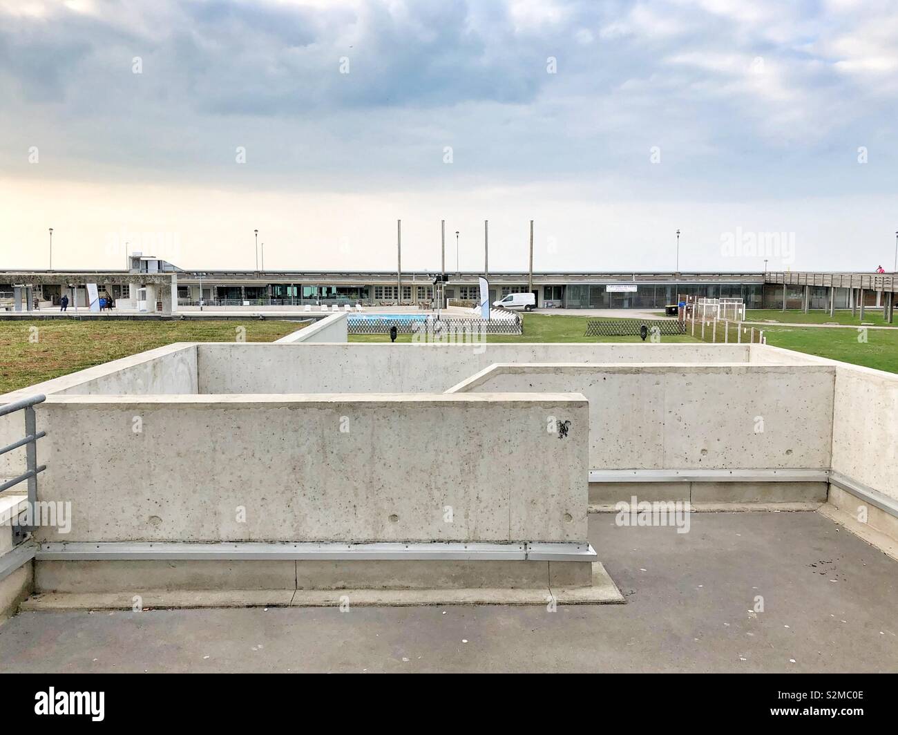 Voir le centre aquatique de Dieppe au bord de l'eau avec escalier en béton à l'avant-plan. Banque D'Images